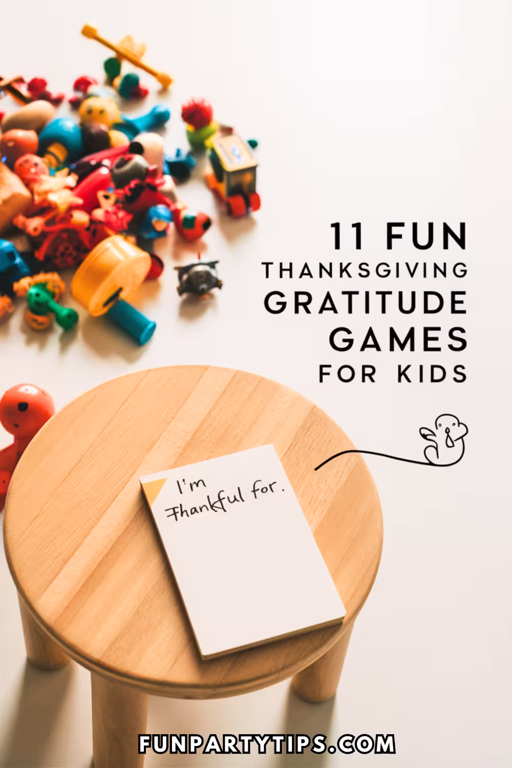 Colorful-scene-of-toys-scattered-on-a-white-surface-with-a-wooden-stool-holding-a-card-that-reads-I’m-thankful-for.-Text-on-the-image-says-11-Fun-Thanksgiving-Gratitude-Games-For-Kids.-This-image-represents-gratitude-activities-and-Thanksgiving-gratitude-games-for-kids.