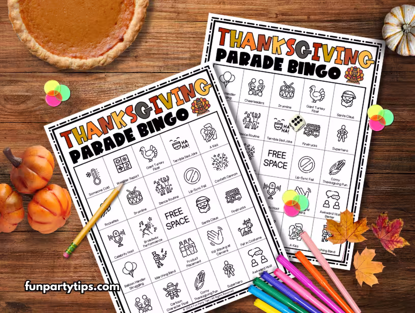 A-top-view-of-a-Thanksgiving-Parade-Bingo-game-set-up-on-a-wooden-table-with-fall-decorations.-This-fun-family-game-for-Thanksgiving-includes-colorful-markers-and-pencils-to-enhance-the-bingo-experience-during-the-holiday.-Family-Game-for-Thanksgiving.