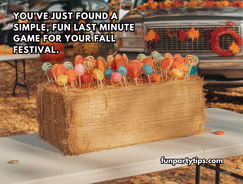 A-straw-bale-decorated-with-colorful-lollipops-at-a-fall-festival,-perfect-for-a-fall-lollipop-pull-game,-with-a-Halloween-themed-backdrop-including-a-truck-and-harvest-decorations.