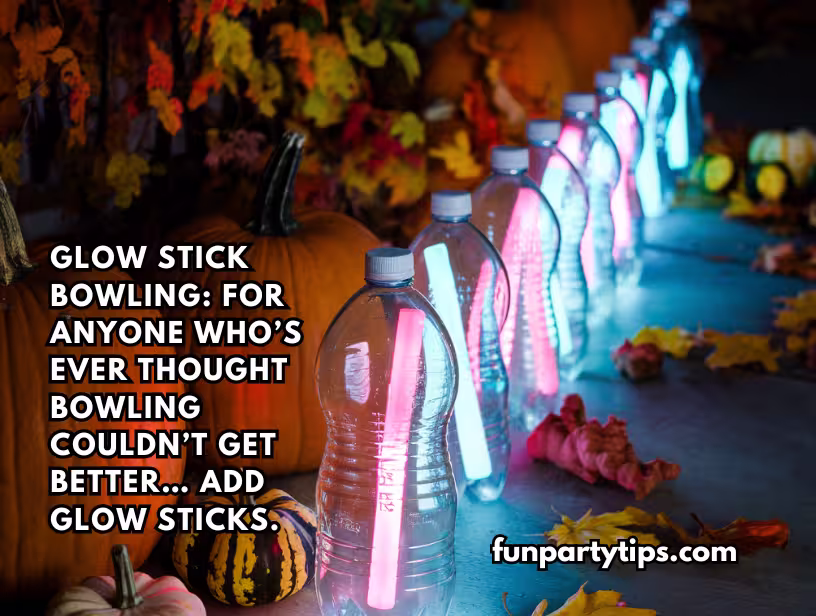 Water-bottles-with-glow-sticks-inside-set-up-as-bowling-pins-on-a-driveway-surrounded-by-pumpkins-and-fall-leaves.-This-fun-fall-game-for-teens-is-glow-stick-bowling-which-adds-a-cool-twist-to-regular-bowling.