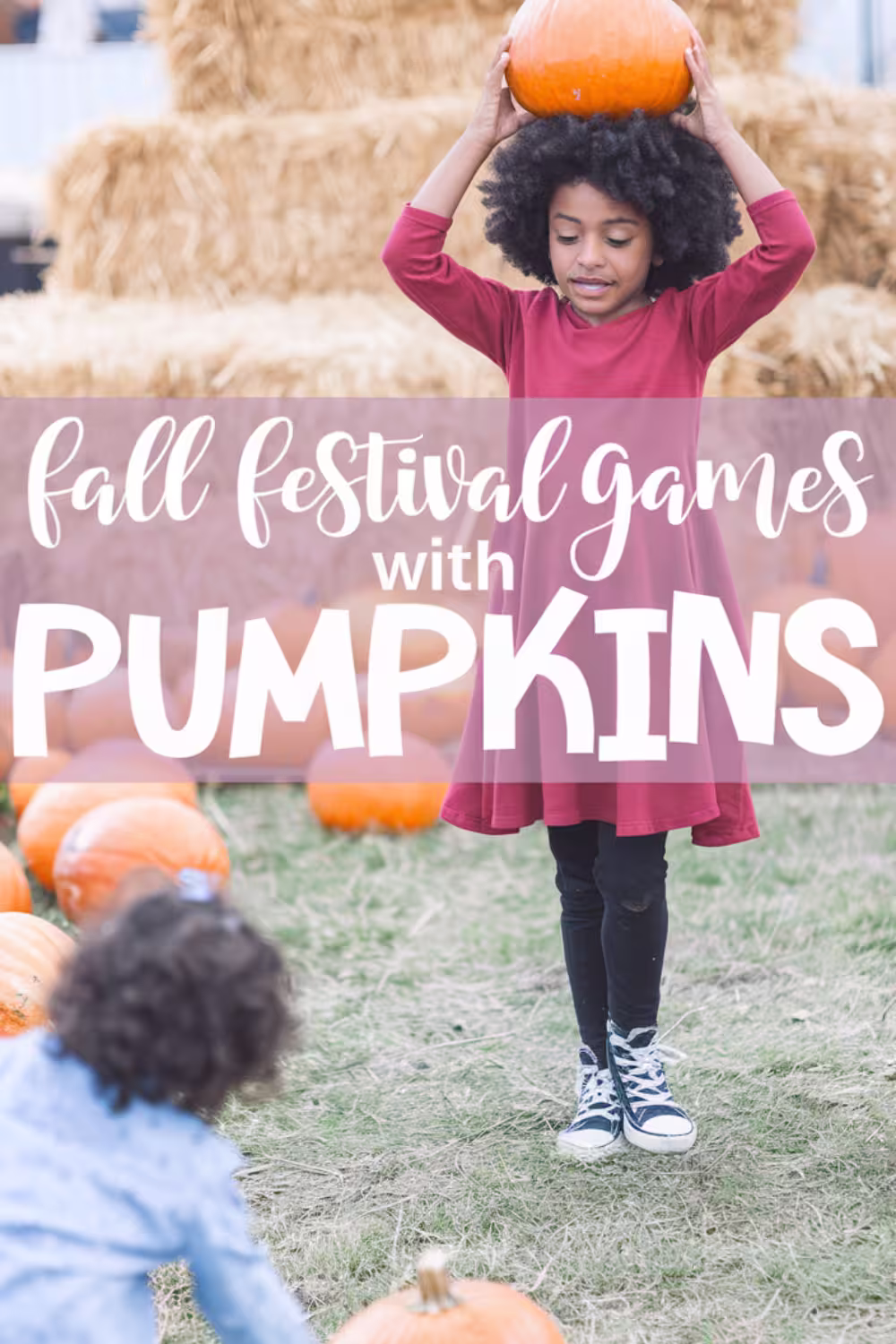 Young-girl-in-red-dress-lifting-pumpkin-above-head,-demonstrating-creative-fall-festival-games-with-pumpkins.
